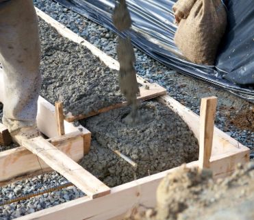 Wet concrete poured into wood forms with rebar — photo published on the ACC Construction site